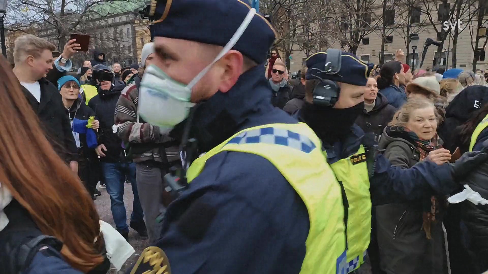 Bildruta från avsnitt 2: poliser och demonstranter i en folksamling